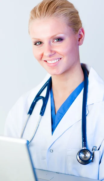 Doctor working on a laptop looking at camera — Stock Photo, Image