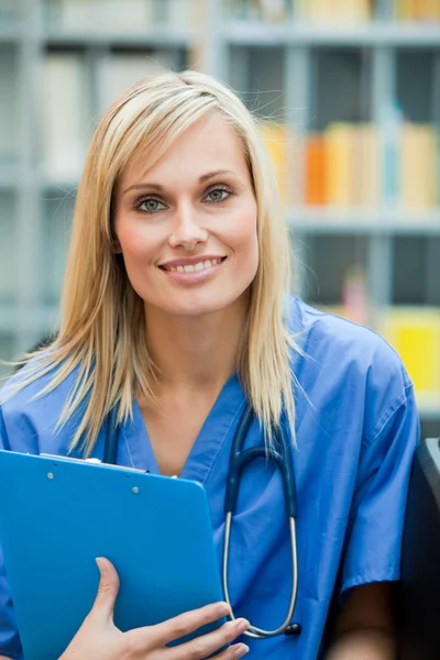 Jonge blonde dokter op het werk op de camera glimlachen — Stockfoto