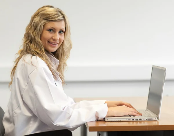 Красивая женщина-хирург работает на ноутбуке — стоковое фото
