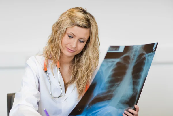 Bela cirurgiã segurando um relatório de raio-X — Fotografia de Stock