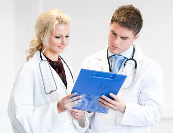 Dois médicos simpáticos a ver um relatório — Fotografia de Stock
