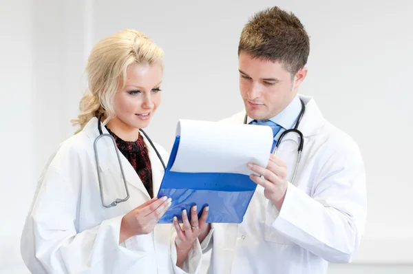 Two nice doctors looking at a report — Stock Photo, Image
