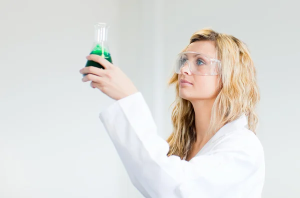 Donna in lapcoat guardando prodotti chimici — Foto Stock