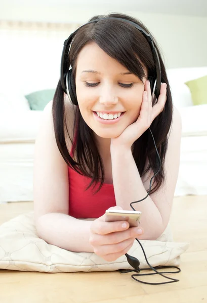 Stralende vrouw luisteren muziek met koptelefoon op — Stockfoto