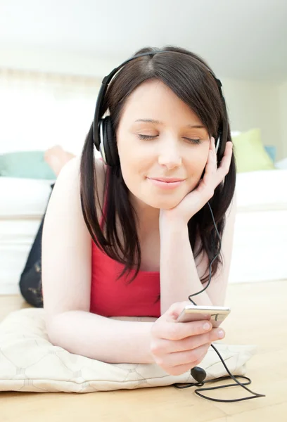 Heldere vrouw luisteren muziek met koptelefoon op — Stockfoto