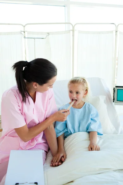 Enfermera atractiva examinando a un poco paciente femenino — Stockfoto