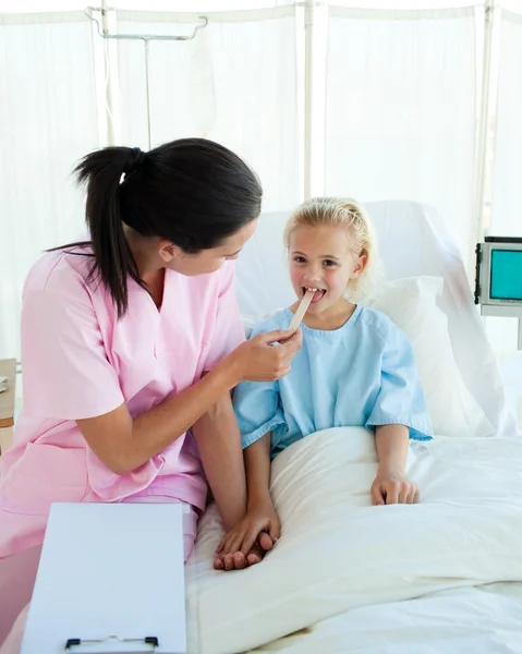 Jovem enfermeira assistindo uma criança paciente — Fotografia de Stock