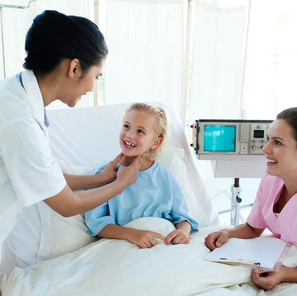 Lachende arts bijwonen van een jonge patiënt — Stockfoto