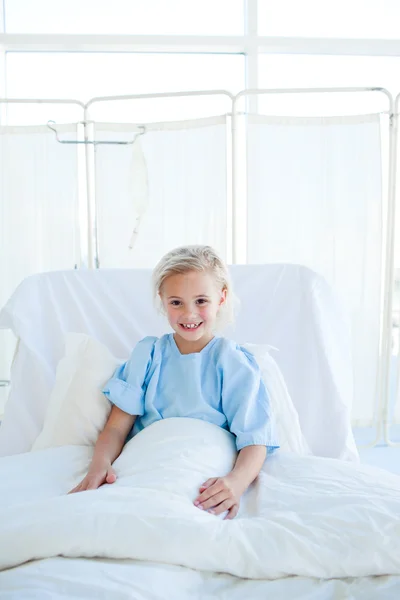 Smiling blond girl on a hospital bed — Stock Photo, Image
