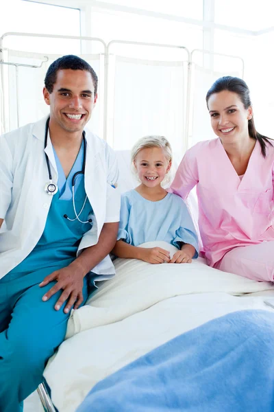 Een arts en een verpleegster met hun kleine patiënt — Stockfoto