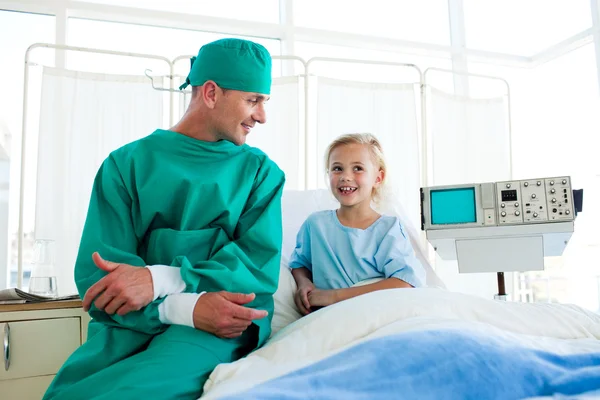 Привлекательный хирург, объясняющий операцию ребенку — стоковое фото