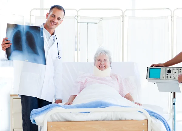 Una paziente con un collare che guarda una radiografia con il suo medico — Foto Stock