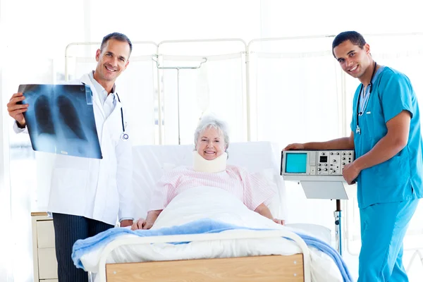 Äldre patienten tittar på en röntgenbild med hennes läkare — Stockfoto