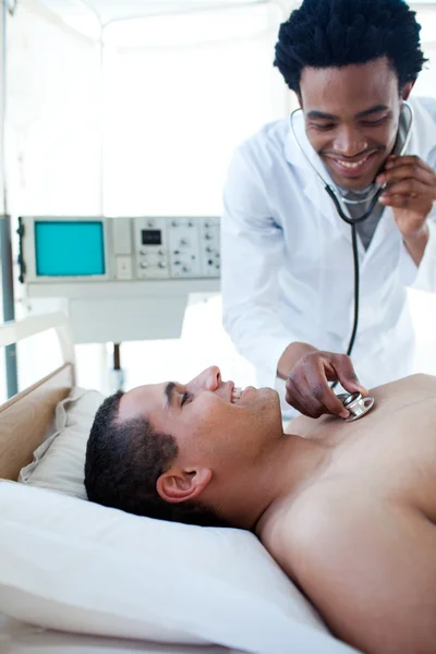 Lächelnder Arzt überprüft den Puls eines männlichen Patienten — Stockfoto