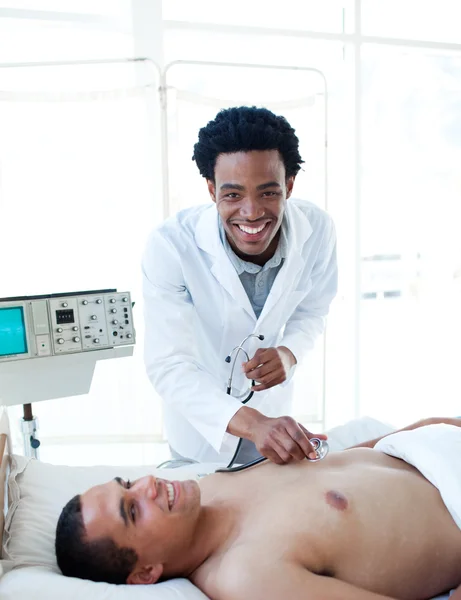 Médico afro-americano examinando um paciente — Fotografia de Stock