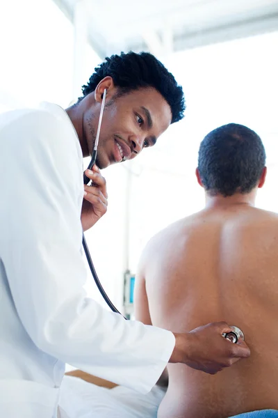 Attraktiver Arzt, der einen Patienten behandelt — Stockfoto