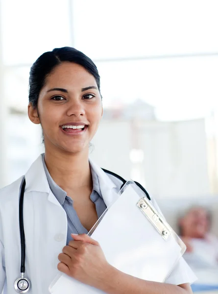 Lachende vrouwelijke arts een medische klembord houden — Stockfoto