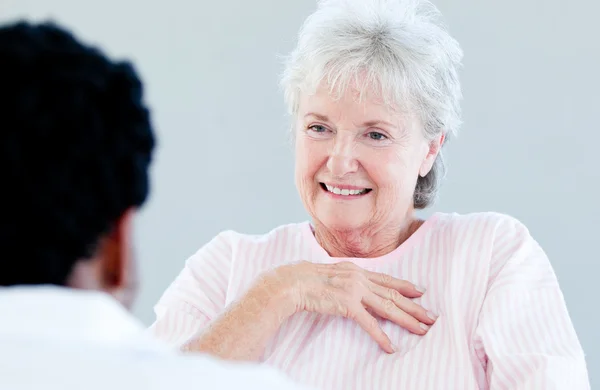 stock image Smiling senior patient sitting on a wheelchair talking with her