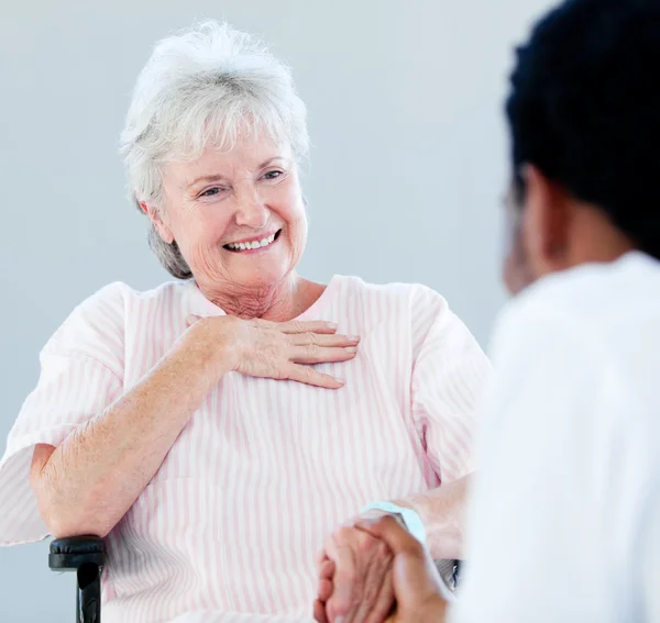 Senior woman sitting on a wheelchair talking with her doctor — Stock Photo, Image