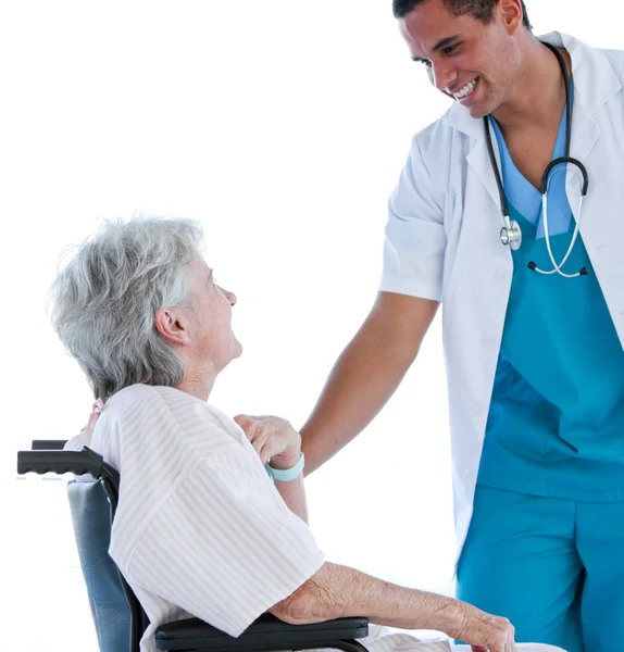 Paciente sênior sentada em uma cadeira de rodas conversando com seu médico — Fotografia de Stock