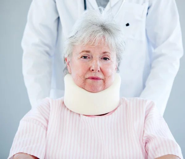 Retrato de una mujer mayor con un corsé en el cuello sentado en una rueda —  Fotos de Stock