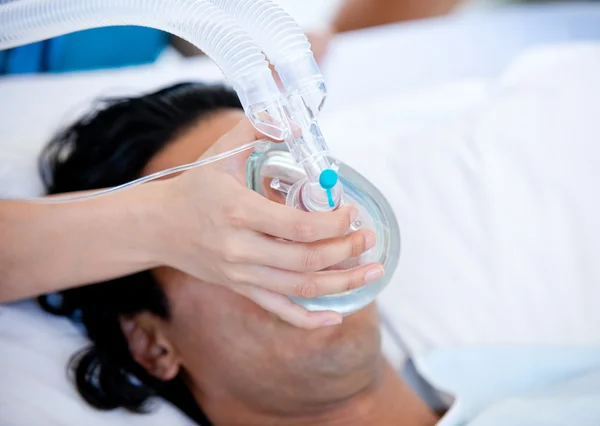 Доктор, который дает кислородную маску пациенту — стоковое фото