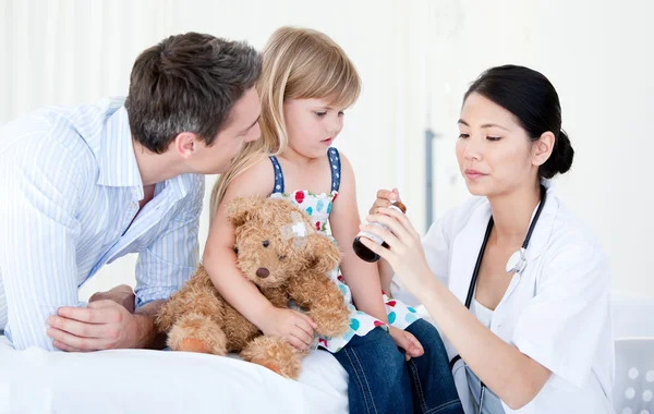 Confident asian female doctor giving syrup to a little girl — Stock Photo, Image