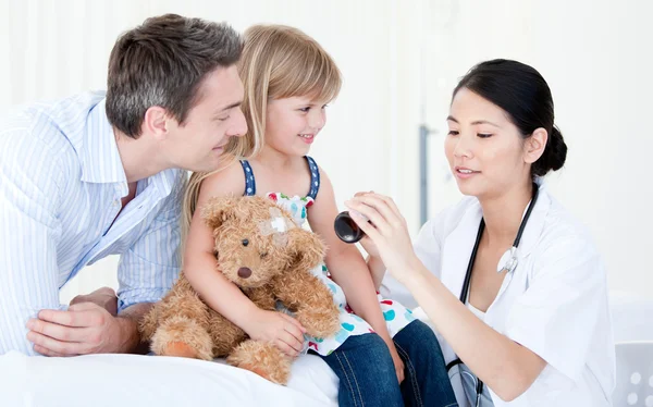 Konzentrierte asiatische Ärztin gibt Sirup an ein kleines Mädchen — Stockfoto