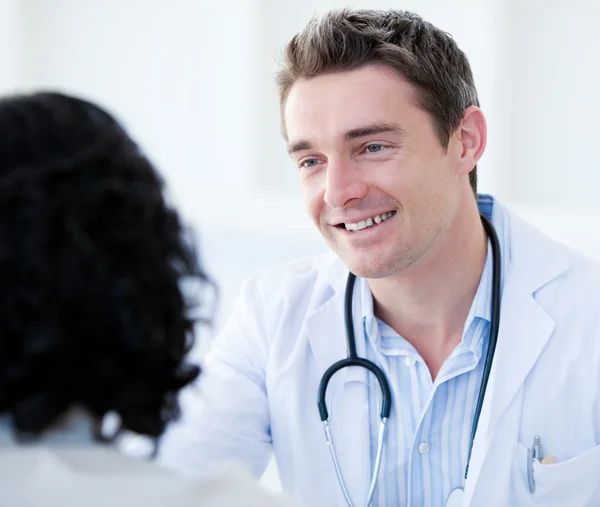 Porträt eines gutaussehenden Arztes, der mit seinem Patienten zum ersten Mal spricht — Stockfoto