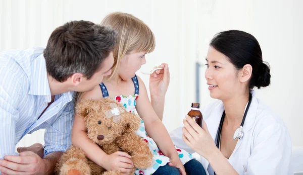 Professional female doctor giving syrup to a little girl — Stock Photo, Image