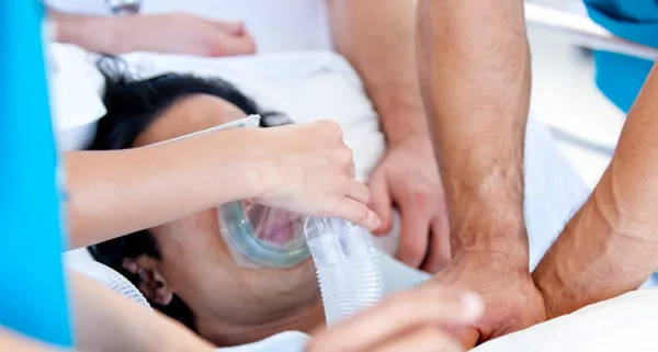 Медицинская команда дает пациенту кислородную маску — стоковое фото