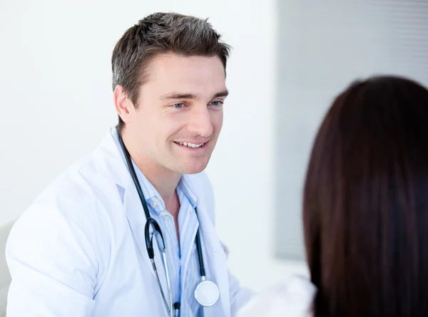 Улыбающийся доктор разговаривает со своим пациентом — стоковое фото