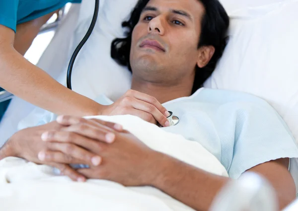 Hiszpanin przeglądane pacjenta przez lekarza na łóżko medycznych — Zdjęcie stockowe