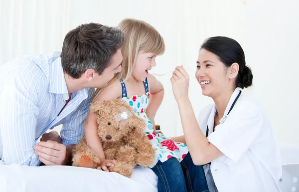 Профессиональная женщина-врач дает сироп милой маленькой девочке — стоковое фото