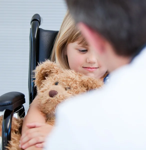 Male doctor talking with a disabled little girl — Stockfoto