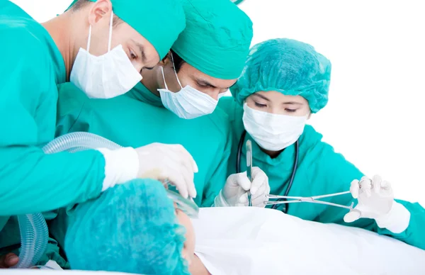 Equipo médico profesional que utiliza equipo quirúrgico en un paciente — Foto de Stock
