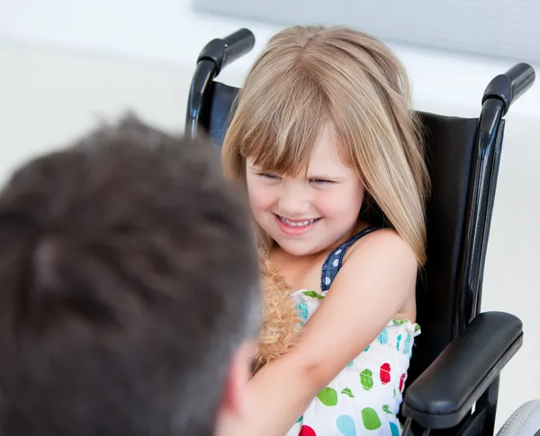 Зарезервированная маленькая девочка, сидящая на инвалидной коляске — стоковое фото