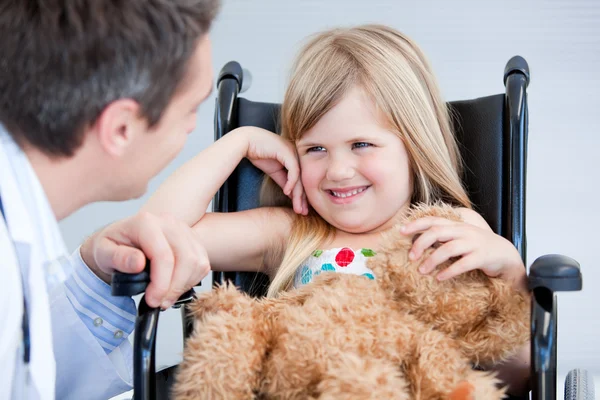Смеющаяся маленькая девочка, сидящая на инвалидном кресле — стоковое фото