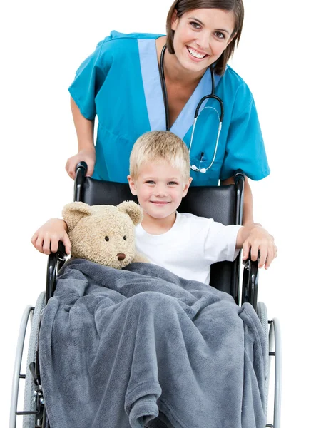 Médico fêmea bonita carregando menino adorável na roda — Fotografia de Stock
