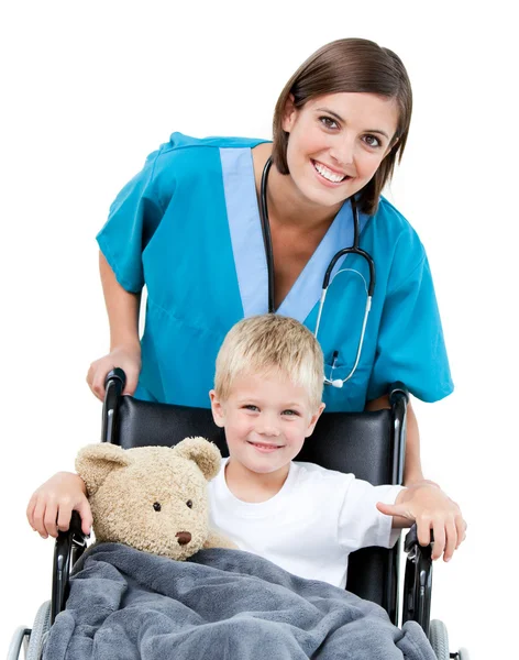 Schöne Ärztin trägt entzückenden kleinen Jungen in der wheelchai — Stockfoto