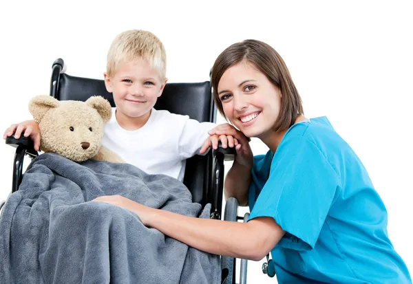 Nice female doctor carrying adorable little boy with his teddy b — Stock Photo, Image