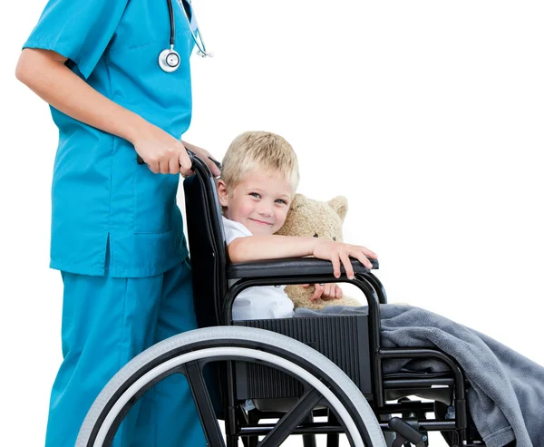 Brillante doctora llevando adorable niño pequeño con su peluche —  Fotos de Stock