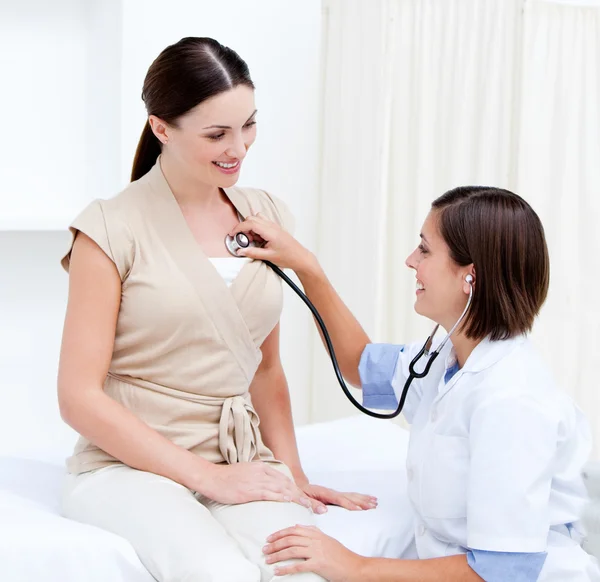 Doctora examinando a una paciente sonriente con su steth — Foto de Stock