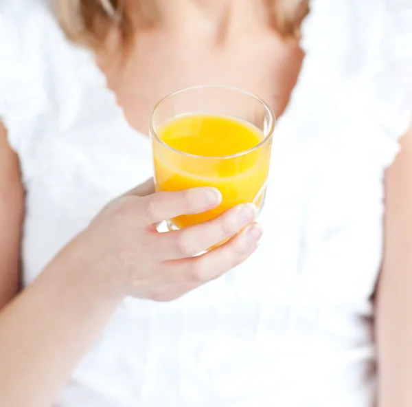Close-up de uma jovem segurando um suco de laranja — Fotografia de Stock
