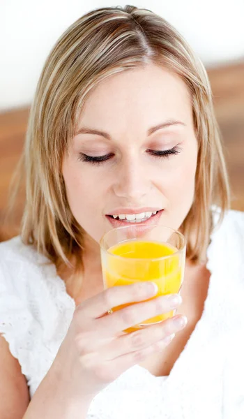 Retrato de uma bela mulher segurando um suco de laranja — Fotografia de Stock