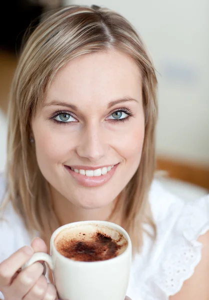 Okouzlující žena, pití kávy, sedí na pohovce — Stock fotografie