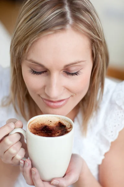 Genç kadın kanepede oturup bir kahve içme — Stok fotoğraf