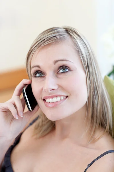 Atraktivní žena mluví telefonu sedí na pohovce — Stock fotografie