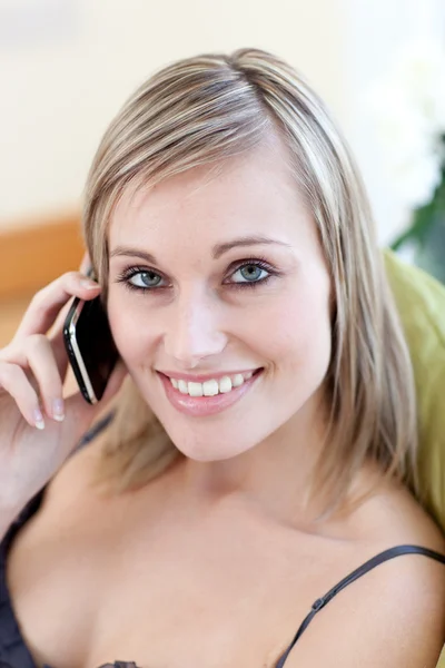 Stralende vrouw praten over telefoon zittend op een bank — Stockfoto