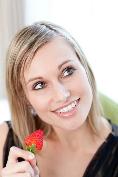 Aufgeweckte Frau isst eine Erdbeere — Stockfoto